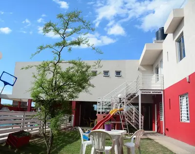 a playground with a slide in the yard of a building at Cerros de la Villa in Villa Carlos Paz