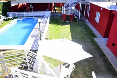 an overhead view of a pool with a table and umbrella at Cerros de la Villa in Villa Carlos Paz