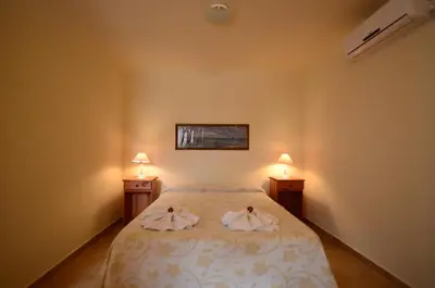 a bedroom with a bed with two towels on it at Cerros de la Villa in Villa Carlos Paz