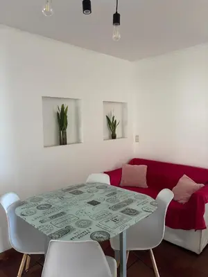 a dining room table with white chairs and a red couch at Nueva Cordoba Illia 611 in Cordoba