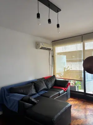 a living room with a black couch and a window at Nueva Cordoba Illia 611 in Cordoba