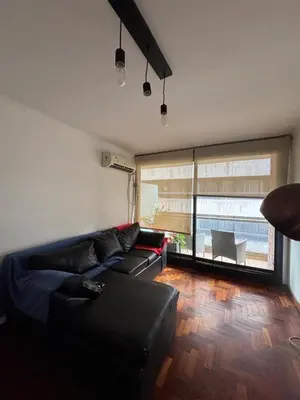 a living room with a black couch and a window at Nueva Cordoba Illia 611 in Cordoba