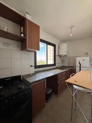 a kitchen with a stove and a table and a window at Nueva Cordoba Illia 611 in Cordoba