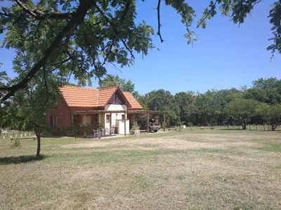 a building in a field with trees in the background at Cabañas el Ñato in Nono