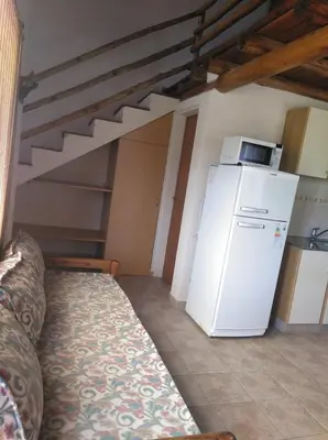 a kitchen with a white refrigerator and a staircase at Cabañas el Ñato in Nono