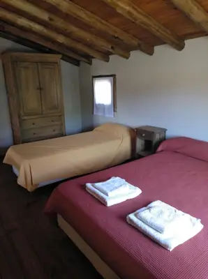two beds sitting next to each other in a room at Cabañas el Ñato in Nono