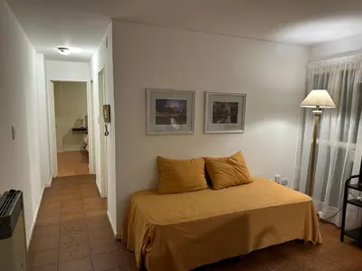 a bedroom with a bed with yellow sheets and a lamp at Centro -Patio Olmos-home office - internet rápida- in Cordoba