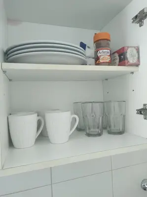 a kitchen shelf with dishes and cups on it at Centro -Patio Olmos-home office - internet rápida- in Cordoba