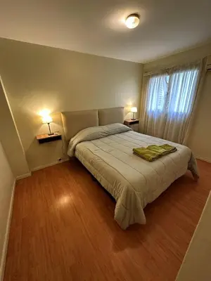 a bedroom with a bed and two lamps and a window at Centro -Patio Olmos-home office - internet rápida- in Cordoba