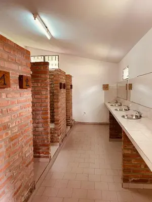 a bathroom with two sinks and a brick wall at Complejo Las Sierras in Nono