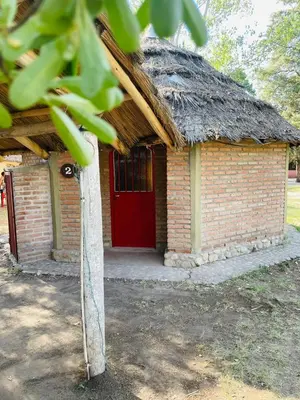 a small brick building with a red door at Complejo Las Sierras in Nono