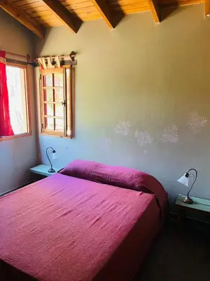 a bedroom with a bed with a pink blanket at Complejo Las Sierras in Nono
