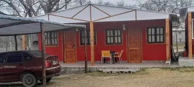 a red and white house with a car parked in front at AYRES DE MONTAÑA in San Ignacio