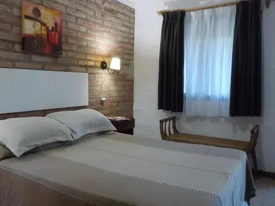 a bedroom with a large bed with a window at Portal del Río Posada in Santa Rosa de Calamuchita