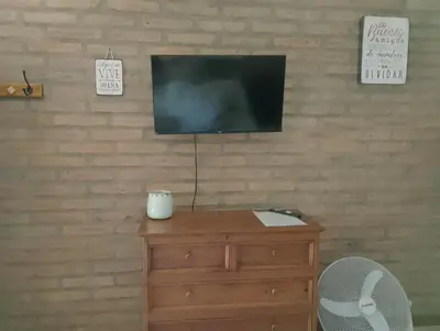 a television sitting on top of a wooden dresser at Portal del Río Posada in Santa Rosa de Calamuchita