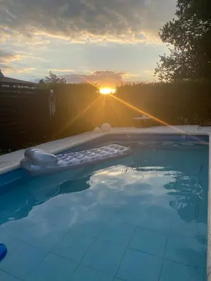 a swimming pool with the sunset in the background at TANTI casa con pileta in Cordoba