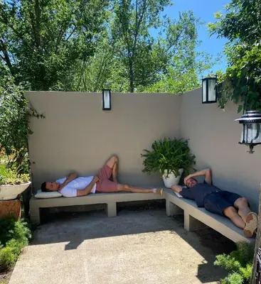 a group of three people laying on a bench at TANTI casa con pileta in Cordoba