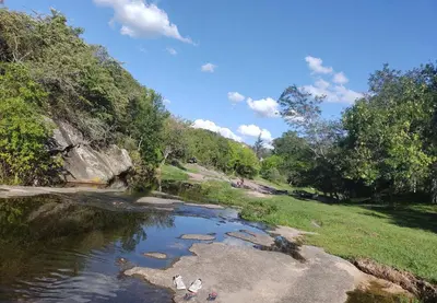 a group of three people standing in a river at TANTI casa con pileta in Cordoba