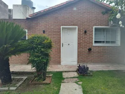 a red brick house with a white door at Departamento W R T 2 in Villa Carlos Paz
