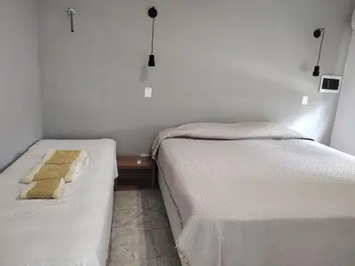 two twin beds in a room with a table at Departamento W R T 2 in Villa Carlos Paz