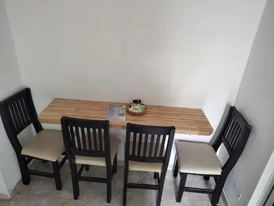 a table with three chairs and a wooden table with a tableablish at Departamento W R T 2 in Villa Carlos Paz