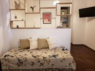 a bed in a room with shelves on the wall at Departamento en Barrio General Paz calle 25 de Mayo in Cordoba