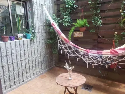 a hammock on a patio with a table and potted plants at Departamento en Barrio General Paz calle 25 de Mayo in Cordoba