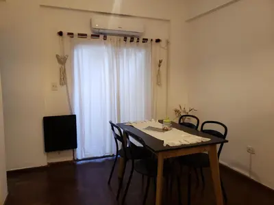 a room with a table and chairs and a television at Departamento en Barrio General Paz calle 25 de Mayo in Cordoba