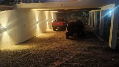 two cars parked in a garage at night at Cabañas Nakupenda in Villa Carlos Paz