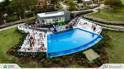 a group of people standing around a swimming pool at VENETO VILLAGE MR in Villa Parque Siquiman