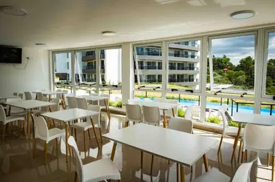 a restaurant with tables and chairs and a large window at VENETO VILLAGE MR in Villa Parque Siquiman