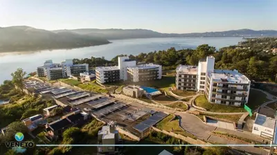 an aerial view of a building next to a body of water at VENETO VILLAGE MR in Villa Parque Siquiman