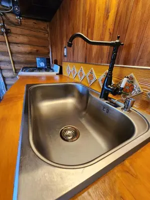 a kitchen sink with a faucet on a counter at Talasuas -aires de montaña in Villa General Belgrano