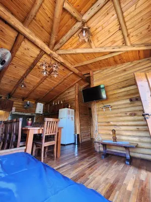 a dining room and kitchen in a log cabin at Talasuas -aires de montaña in Villa General Belgrano