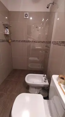 a bathroom with a toilet and a sink at Depto céntrico excelente ubicación, con cochera, pileta y patio in Villa Carlos Paz