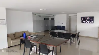 a room with a table and chairs and a couch at Depto céntrico excelente ubicación, con cochera, pileta y patio in Villa Carlos Paz
