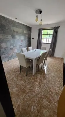a dining room with a white table and chairs at La Calera- Casa vacacional in La Calera