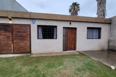 a house with two garage doors and two palm trees at La Calera- Casa vacacional in La Calera