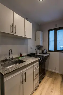 a kitchen with white cabinets and a sink and a window at Hermoso departamento by Lofty in Cordoba