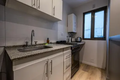 a kitchen with white cabinets and a sink and a window at Hermoso departamento by Lofty in Cordoba