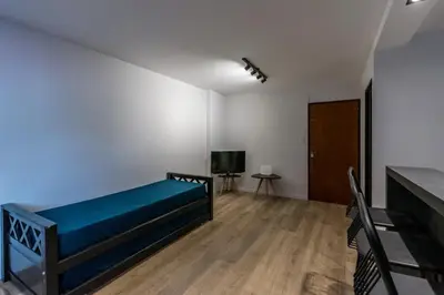 a bedroom with a bed and a desk and a television at Hermoso departamento by Lofty in Cordoba