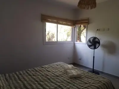 a bedroom with a bed and a window and a fan at Casa Aguaribay para 4 personas, cerca del centro, Merlo San Luis in Merlo