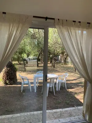 a table and chairs outside a sliding glass door at Casa Aguaribay para 4 personas, cerca del centro, Merlo San Luis in Merlo