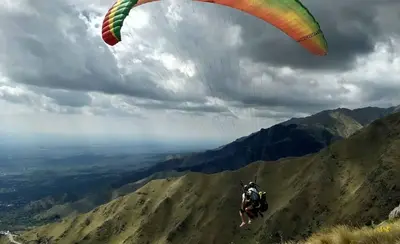 a person flying a parachute on top of a mountain at Casa Aguaribay para 4 personas, cerca del centro, Merlo San Luis in Merlo