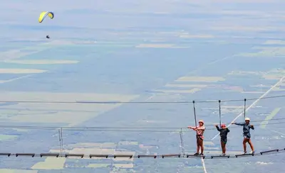three people standing on top of a rope bridge at Casa Aguaribay para 4 personas, cerca del centro, Merlo San Luis in Merlo