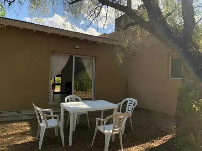 a table and chairs in front of a house at Casa Aguaribay para 4 personas, cerca del centro, Merlo San Luis in Merlo