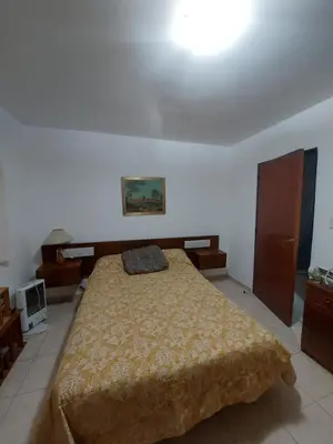 a bedroom with a large bed with a yellow blanket at Casa céntrica en Tanti in Tanti