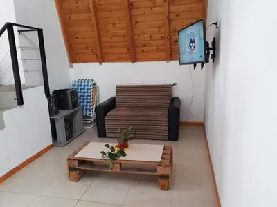 a living room with a couch and a table and a tv at Mi Descanso!!! in Cavalango
