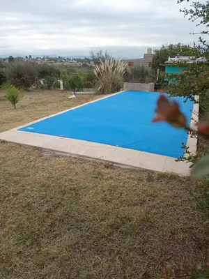 a blue rectangle swimming pool in a yard at Mi Descanso!!! in Cavalango