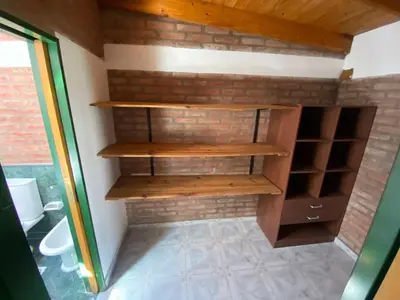 a bathroom with wooden shelves in a brick wall at MIGUEL JUAREZ 47 in Villa Carlos Paz